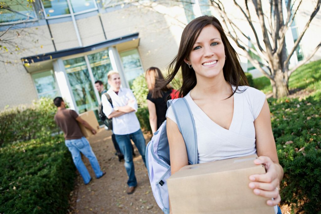 College: Girl Moving Into Dorm with Box