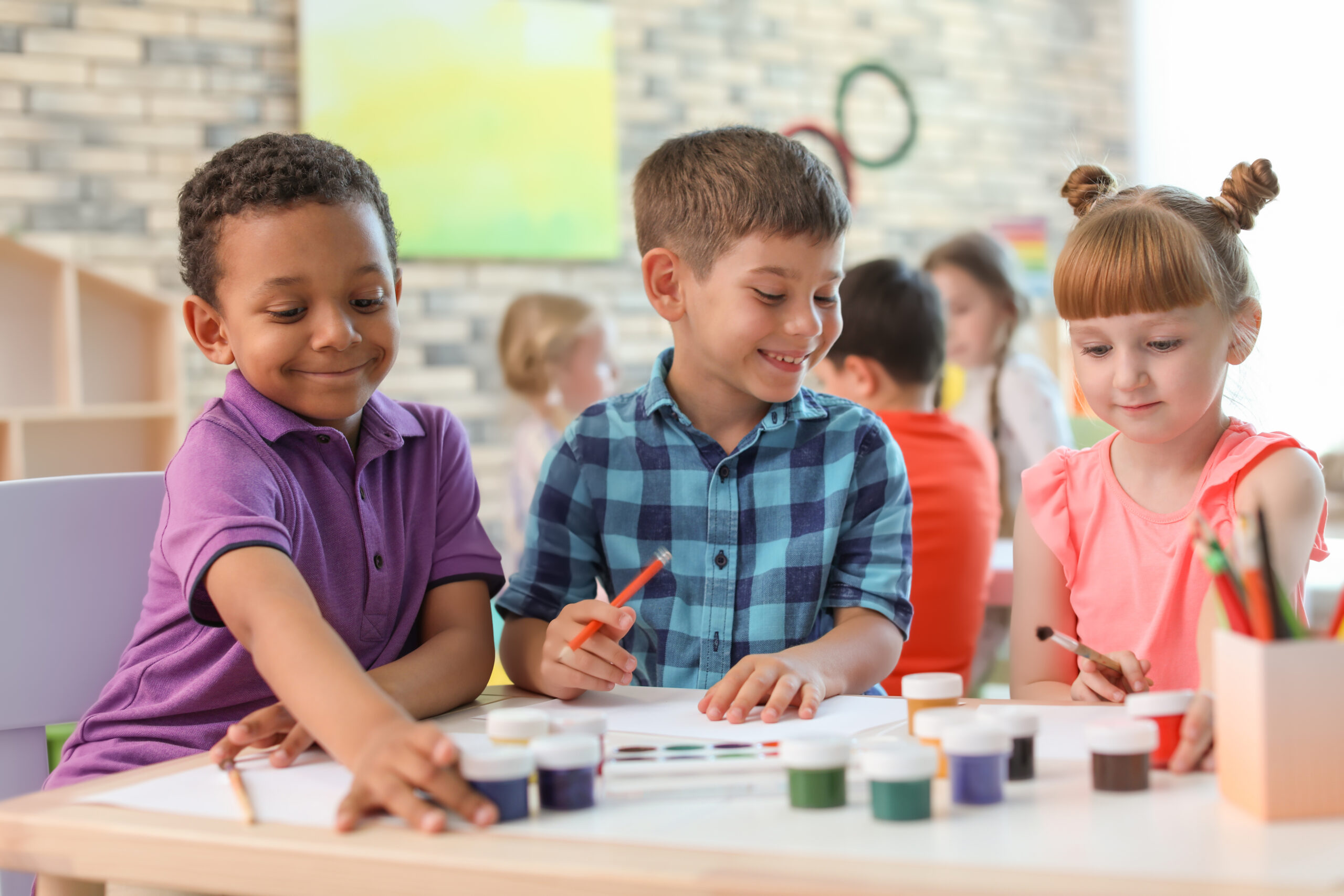 Cute little children painting at table indoors. Learning by playing