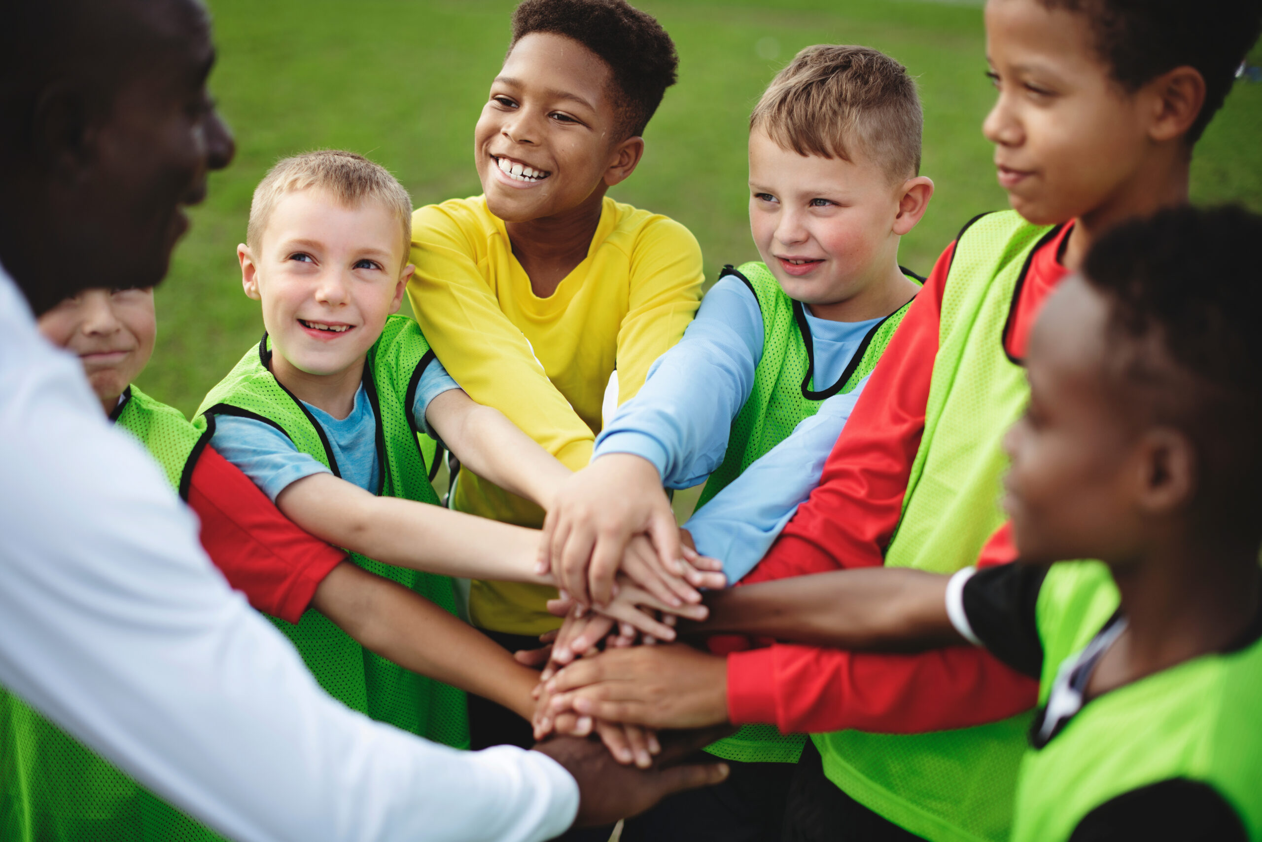 Junior football team stacking hands before a match