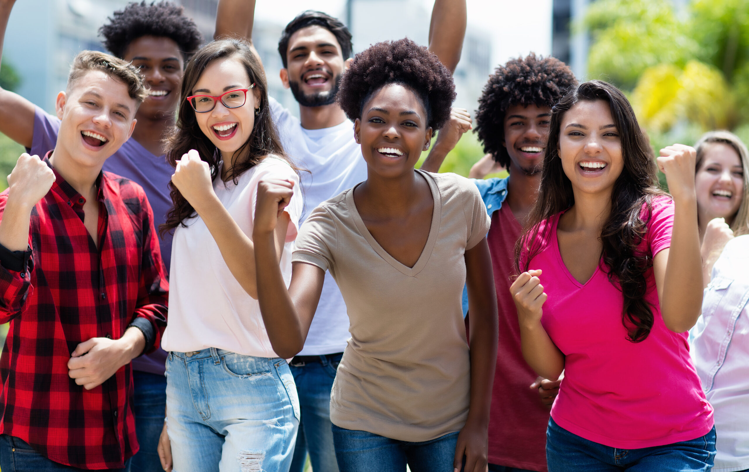 Group of cheering african american and caucasian and hispanic and latin young adults outdoor in summer in city