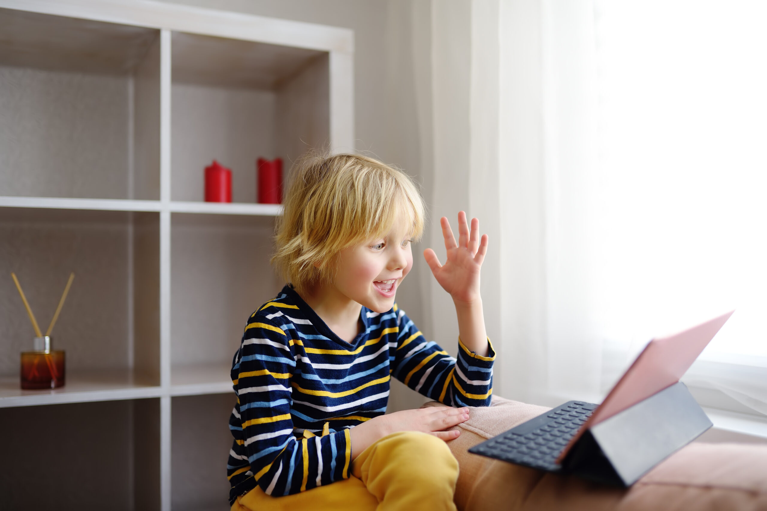 A child talks to a tablet they are using for virtual learning.