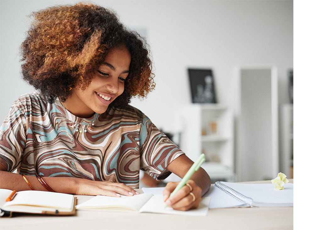 Girl at desk writing in notebook